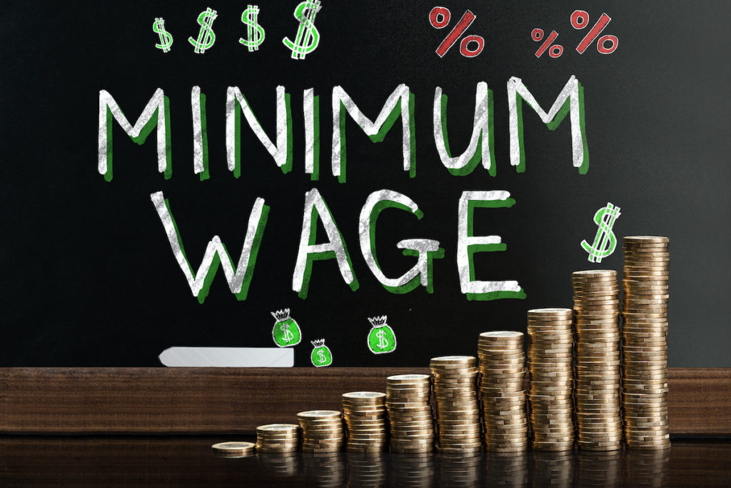 Minimum Wage At Blackboard Minimum Wage At Blackboard Behind Stacked Coins