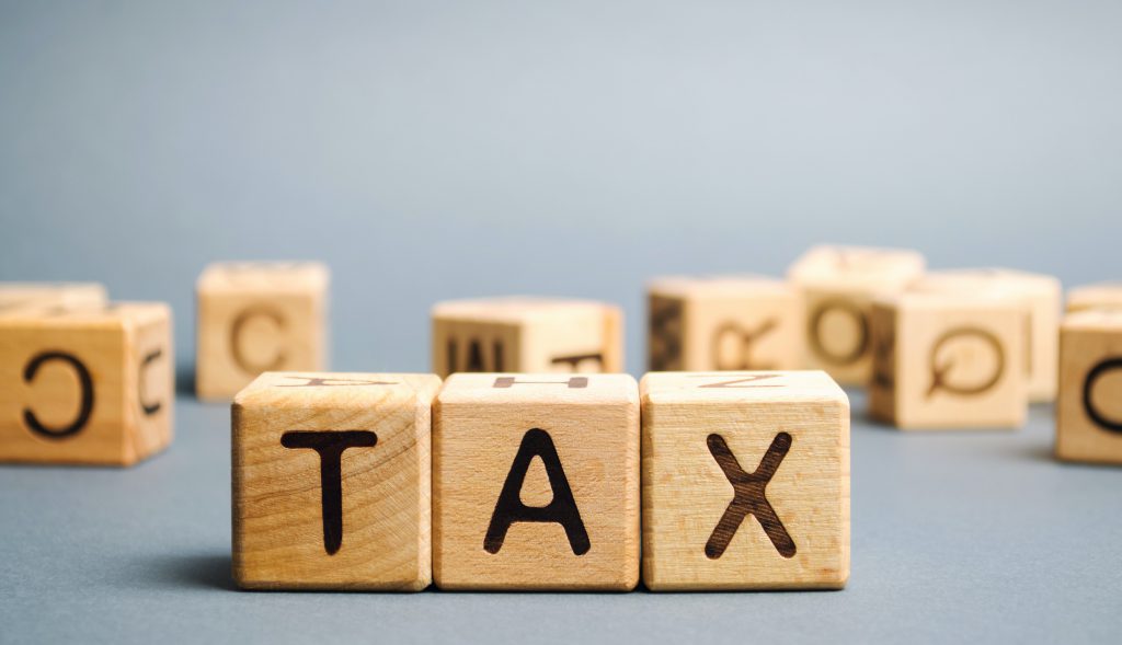 Wooden blocks with the word Tax. Business and finance concept. Taxes and taxation. The tax burden Wooden blocks with the word Tax. Business and finance concept. Taxes and taxation. The tax burden